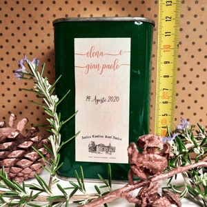 May include: A green metal can with a white label. The label has the text "elena e gian paolo" and "14 Agosto 2020". The label also has the text "Antica Cantina Sant'Amica".