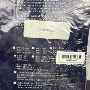 Op de afbeelding: Een verpakking van Ralph Lauren beddengoed. Het label luidt "ANNABELLE" en vermeldt de samenstelling van de stof, waaronder 100% katoen en linnen. Er worden ook onderhoudsinstructies gegeven, waaronder machinewas en professionele chemische reiniging.