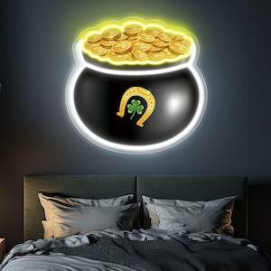 May include: A black pot of gold neon sign with a horseshoe and shamrock design. The pot is filled with gold coins and outlined with a bright white neon glow. The sign is mounted on a dark grey wall above a bed.