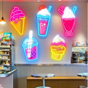 May include: Neon signs of ice cream cones and drinks in a cafe setting. The signs are in bright pink, yellow, and blue colors. The ice cream cone has a pink top and yellow cone. The drinks include a milkshake and bubble tea.