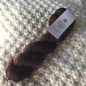 May include: A skein of brown yarn labeled "Seven Sisters Arts" and "Meridian".