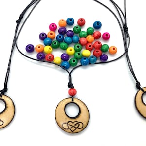 Könnte beinhalten: Drei Holzketten mit einem Herz- und Unendlichkeits-Symbol-Design. Jede Kette hat eine andere Länge und ist aus schwarzem Band und bunten Holzperlen gefertigt.