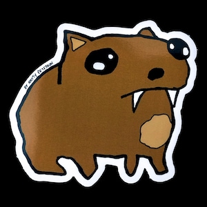 Puede incluir: Un wombat de dibujos animados marrón con ojos grandes y dientes afilados. El wombat está delineado en blanco y tiene una mancha marrón en el vientre. El texto "By Marty Petrin" está escrito en negro en el lado izquierdo de la imagen.