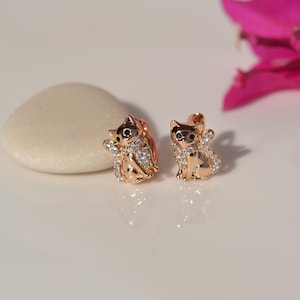 Op de afbeelding: Een paar gouden kattenoorbellen met heldere kristallen accenten.