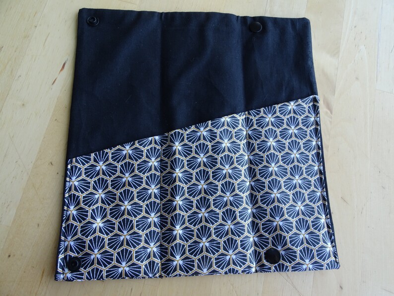 May include: Black fabric pouch with three compartments, lined with a white and gold geometric pattern.