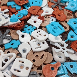 Puede incluir: Una colecci&oacute;n de formas de pl&aacute;stico de colores, incluyendo estrellas, casas y bombillas. Las formas son de varios colores, incluyendo azul, blanco, marr&oacute;n y naranja.