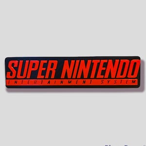 May include: A black and red rectangular sticker with the text "SUPER NINTENDO ENTERTAINMENT SYSTEM".