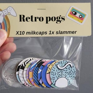 May include: A clear plastic bag containing ten milkcaps and one slammer. The milkcaps feature colourful retro designs. The packaging reads "Retro pogs" with a joystick and cassette tape graphic.