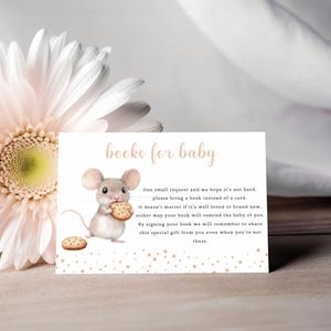 May include: A white card with the text "books for baby" in gold lettering. A cartoon mouse is holding a cookie. The card has a message asking guests to bring a book instead of a card for the baby.