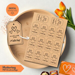 May include: Kraft paper gift tags with heart designs and the text "Alles Liebe zum Muttertag!" are displayed in a wooden bowl. The tags are for Mother's Day and are a digital download.