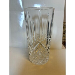 May include: A clear glass with a cut crystal design. The glass is tall and cylindrical.