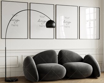 May include: A black arc floor lamp with a black shade illuminates a gray, modern, modular sofa with three rounded cushions. Three black framed posters hang on the wall behind the sofa. The posters have the text "Your design here" on them.