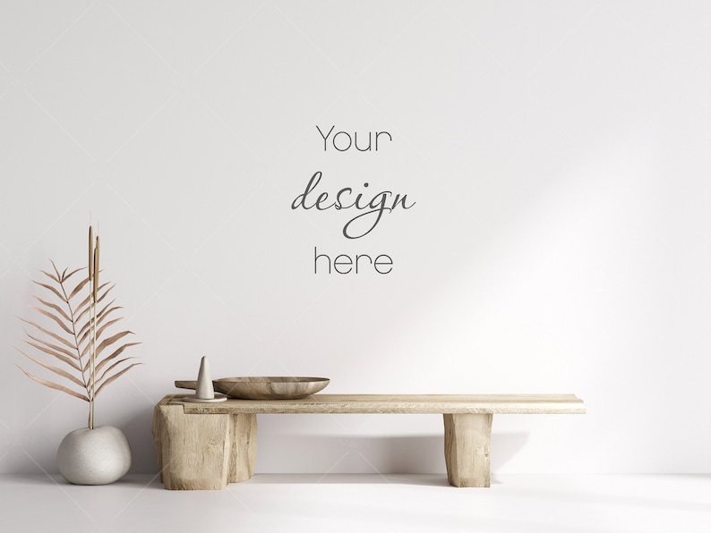Pu&ograve; includere: Una panca di legno con una finitura naturale si trova di fronte a un muro bianco. Un vaso con una palma secca e un piccolo vaso di ceramica bianca sono sulla panca. Il testo "Your design here" &egrave; scritto sul muro.