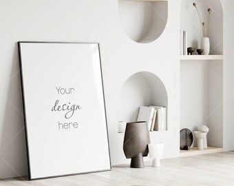 May include: A black framed poster mockup with the text "Your design here" in a white room with a shelf and decorative objects.