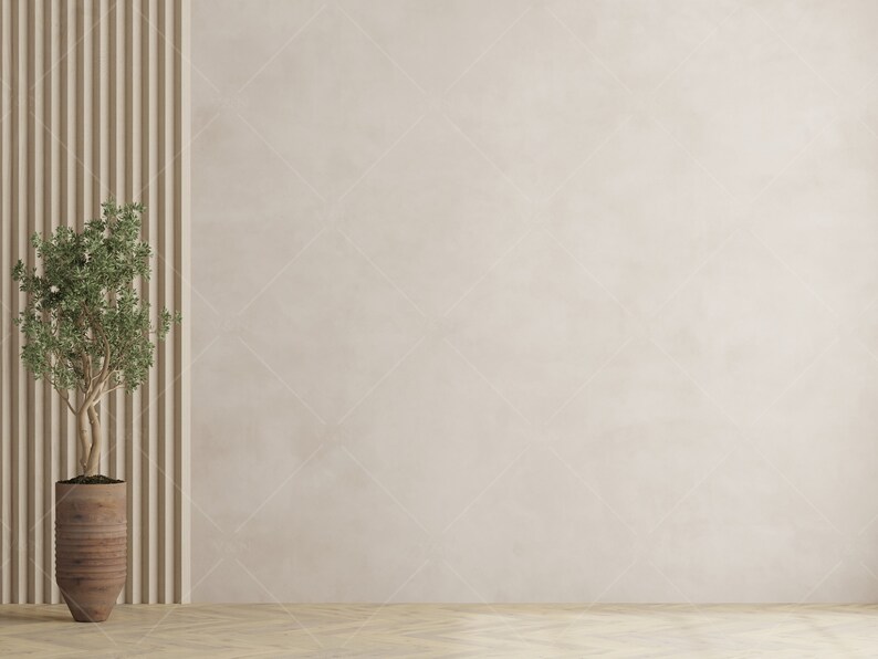 May include: A small potted plant with green leaves in a brown ceramic pot sits in front of a wall with vertical wood panels. The wall is a light beige colour.