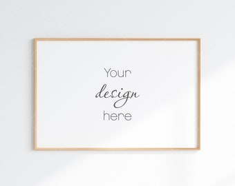 May include: A simple, light wood frame with a white background. The text "Your design here" is written in black cursive font.
