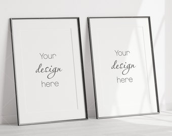 May include: Two black framed pictures with white mats and the text "Your design here" in each.