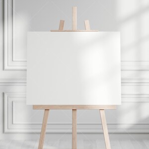 May include: A blank white canvas on a wooden easel in a white room with light shining through the window.