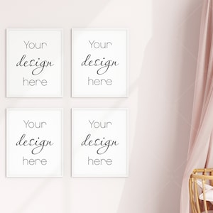 Op de afbeelding: Vier wit ingelijste prints op een lichtroze muur, elk met de tekst "Your design here" in een scriptlettertype. Een roze gordijn en een houten wieg zijn zichtbaar aan de rechterkant van de afbeelding. Het algemene thema is kinderkamerdecoratie.