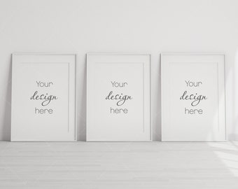 May include: Three white picture frames with black text that reads "Your design here" on a white wall.