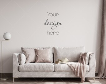 May include: A white sofa with two pillows and a throw blanket, in front of a white wall with the text "Your design here".