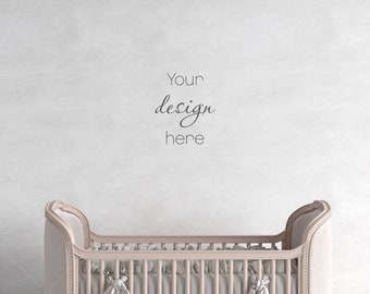 Puede incluir: Una cuna blanca con un colchón rosa claro y una pared blanca con el texto "Your design here" en negro.