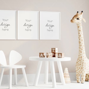 Puede incluir: Una mesa de madera blanca con una silla de madera blanca y un juguete de peluche de jirafa. La mesa tiene bloques de madera que deletrean "A, V, G, F, R, S, Z" en la parte superior. Hay tres marcos blancos en la pared detrás de la mesa con el texto "Your design here" en cada marco.