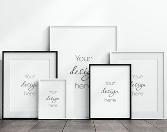 May include: Five white picture frames with black frames, arranged in a staggered formation on a wooden floor. The frames are empty and ready for your design. The text "Your design here" is written in each frame.