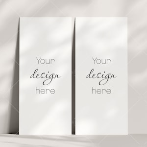 May include: Two blank white cards with the text "Your design here" on each card. The cards are standing upright on a white surface with shadows cast from above.