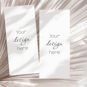 May include: Two blank white cards with the text "Your design here" on each card, placed on a beige palm leaf background.