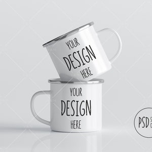 Könnte beinhalten: Zwei weiße Emailletassen mit silbernen Rändern, die übereinander gestapelt sind. Die Tassen haben schwarzen Text mit der Aufschrift "Your Design Here".