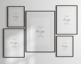 May include: Five black picture frames with white mats on a white wall. The frames are arranged in a staggered pattern. The text "Your design here" is written in each frame.