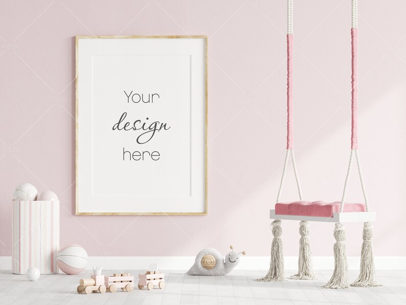Puede incluir: Un contenedor de almacenamiento a rayas rosa y blanco con una pelota blanca y una pelota rosa y blanca a su lado. Un tren de juguete de madera est&aacute; en el suelo frente al contenedor. Un p&oacute;ster enmarcado con el texto "Your design here" est&aacute; en la pared detr&aacute;s del contenedor. Un columpio rosa con borlas blancas cuelga del techo en la esquina derecha de la imagen.