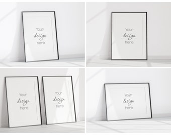 May include: Four black picture frames with white mats on a white background. The frames are empty and have the text "Your design here" written in black cursive inside each frame.