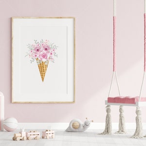 Puede incluir: Una impresi&oacute;n enmarcada de una ilustraci&oacute;n de acuarela de un ramo de flores rosas en un cono de waffle. La impresi&oacute;n est&aacute; colgada en una pared rosa con un columpio blanco en el fondo.
