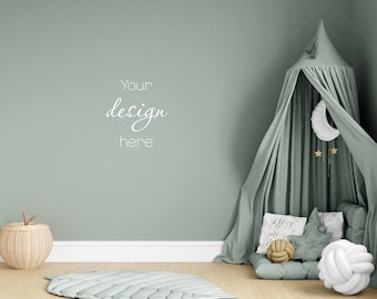 Puede incluir: Una tienda de juegos verde claro con una luna creciente blanca y estrellas colgando de la parte superior. La tienda está instalada en una habitación con una pared verde claro y una cesta tejida con una manzana en la parte superior. El texto "Your design here" está escrito en la pared.