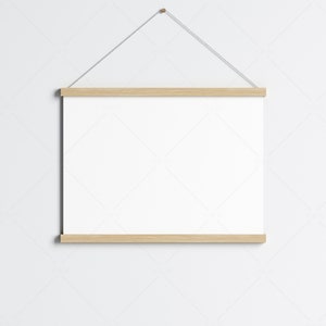 May include: A white poster with a wooden frame hanging on a white wall. The frame is attached to a string.