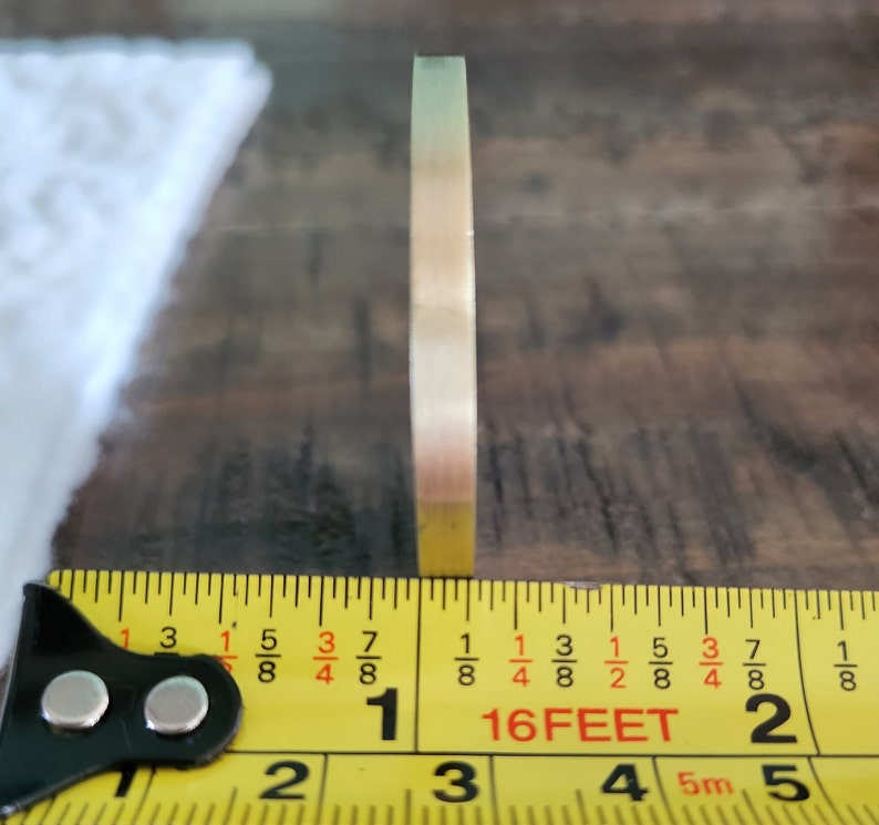 Measurement of coin thickness is 1/8th of an inch, 0.125 inch
