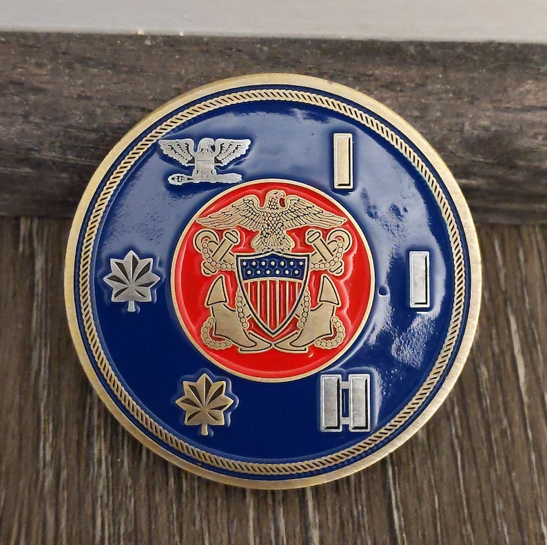 Military challenge coin that has a blue background, Navy officer rank insignia around the clockface edge, and a Navy Officer's crest in the center.