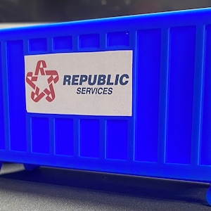 K&ouml;nnte beinhalten: Ein blauer Abfallcontainer mit R&auml;dern und einem wei&szlig;en Etikett mit der Aufschrift "Republic Services".