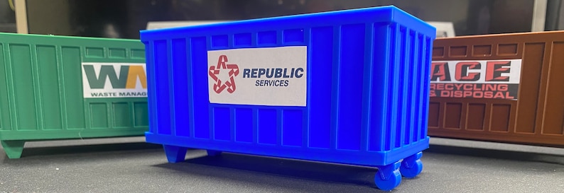 K&ouml;nnte beinhalten: Ein blauer Abfallcontainer mit R&auml;dern und einem wei&szlig;en Etikett mit der Aufschrift "Republic Services".