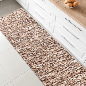 May include: A brown and white patterned runner rug with a shaggy texture. The rug is placed in a kitchen with white cabinets and a wood countertop.