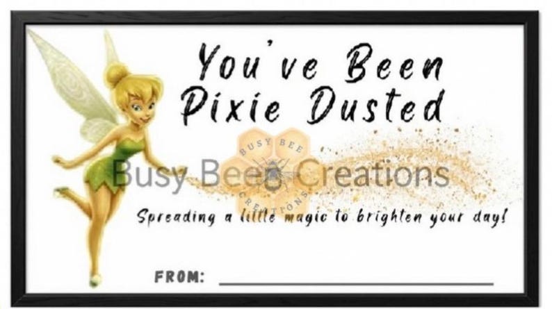 May include: A rectangular sign with a black frame featuring a yellow-haired fairy in a green dress on the left. The text reads You've Been Pixie Dusted, Busy Bee Creations, Spreading a little magic to brighten your day!, and FROM: with a line.