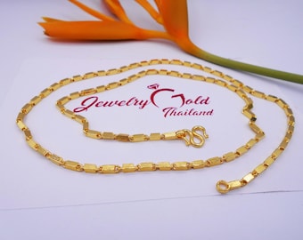 May include: A gold chain necklace with a box chain design. The chain is made of small, square-shaped links. The necklace has a lobster clasp closure.