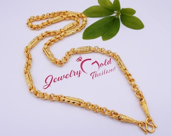 May include: A gold chain necklace with a textured design. The chain is made of linked ovals with a rectangular design in the center of each oval. The chain is 22 inches long and has a lobster clasp closure.