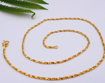 May include: A gold chain necklace with a twisted design. The chain is about 20 inches long and has a lobster clasp.