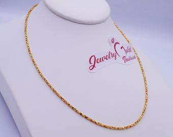 May include: A gold-colored necklace with a textured chain is displayed on a white jewelry bust. The necklace is draped in a circular shape. A sticker with the text "Jewelry Gold Thailand" is visible.