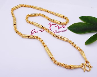May include: A gold chain necklace with a textured design. The chain has a clasp with a hook and loop closure. The chain is on a white background.