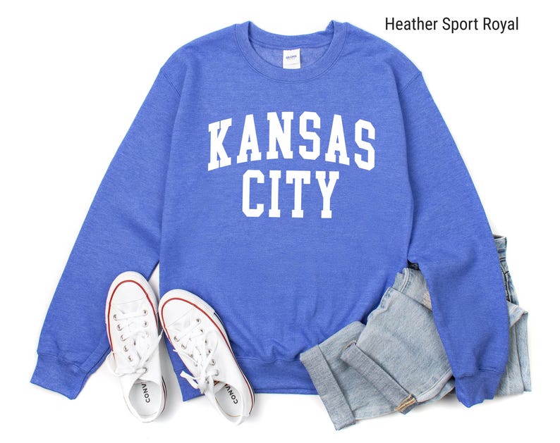 May include: A heather sport royal blue sweatshirt with white text that reads "Kansas City".
