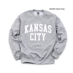 May include: A heather sport gray sweatshirt with the text "KANSAS CITY" printed in white on the front.